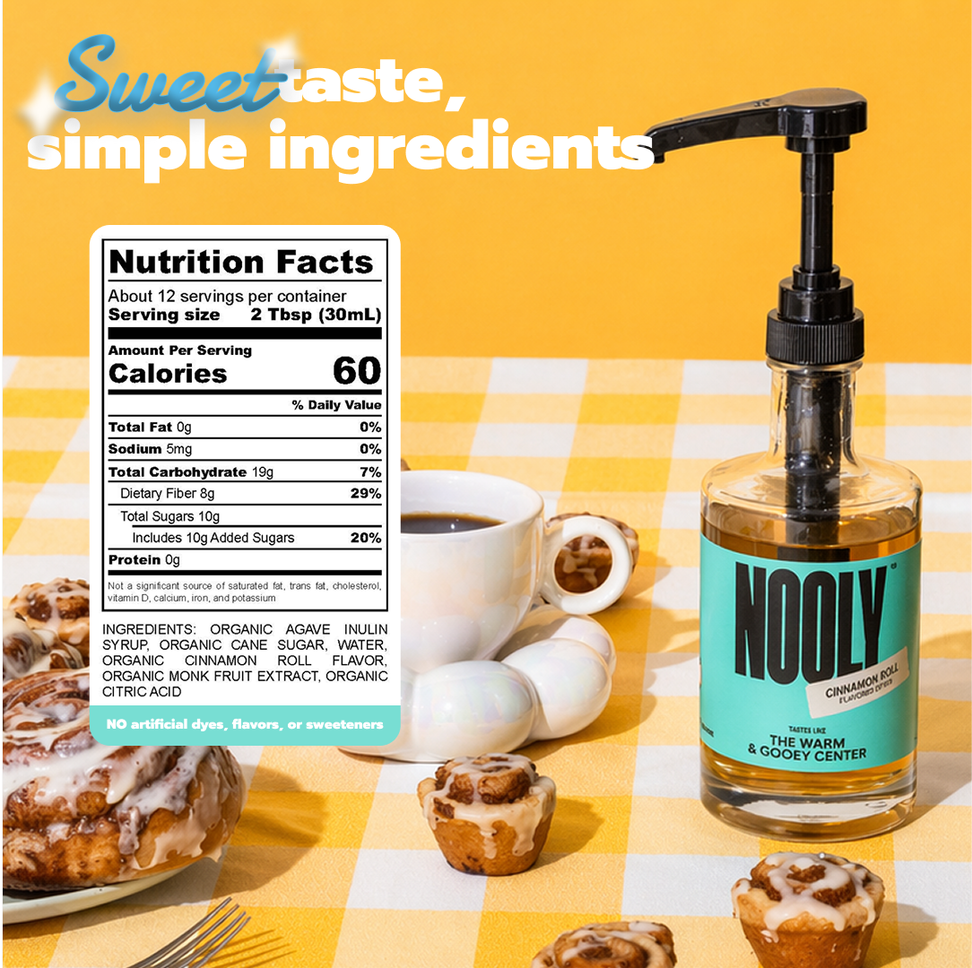 Bottle of Nooly cinnamon roll syrup with a cup of coffee and pastries on a yellow checkered tablecloth.