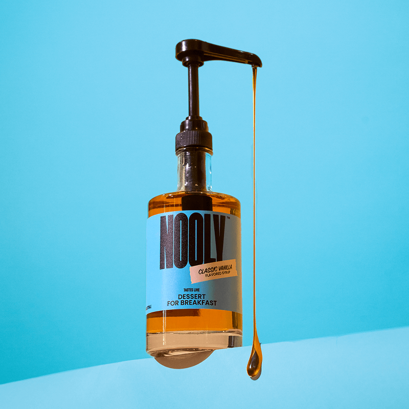 Nooly vanilla coffee syrup bottle with a long drip of vanilla syrup coming out of pump attachment